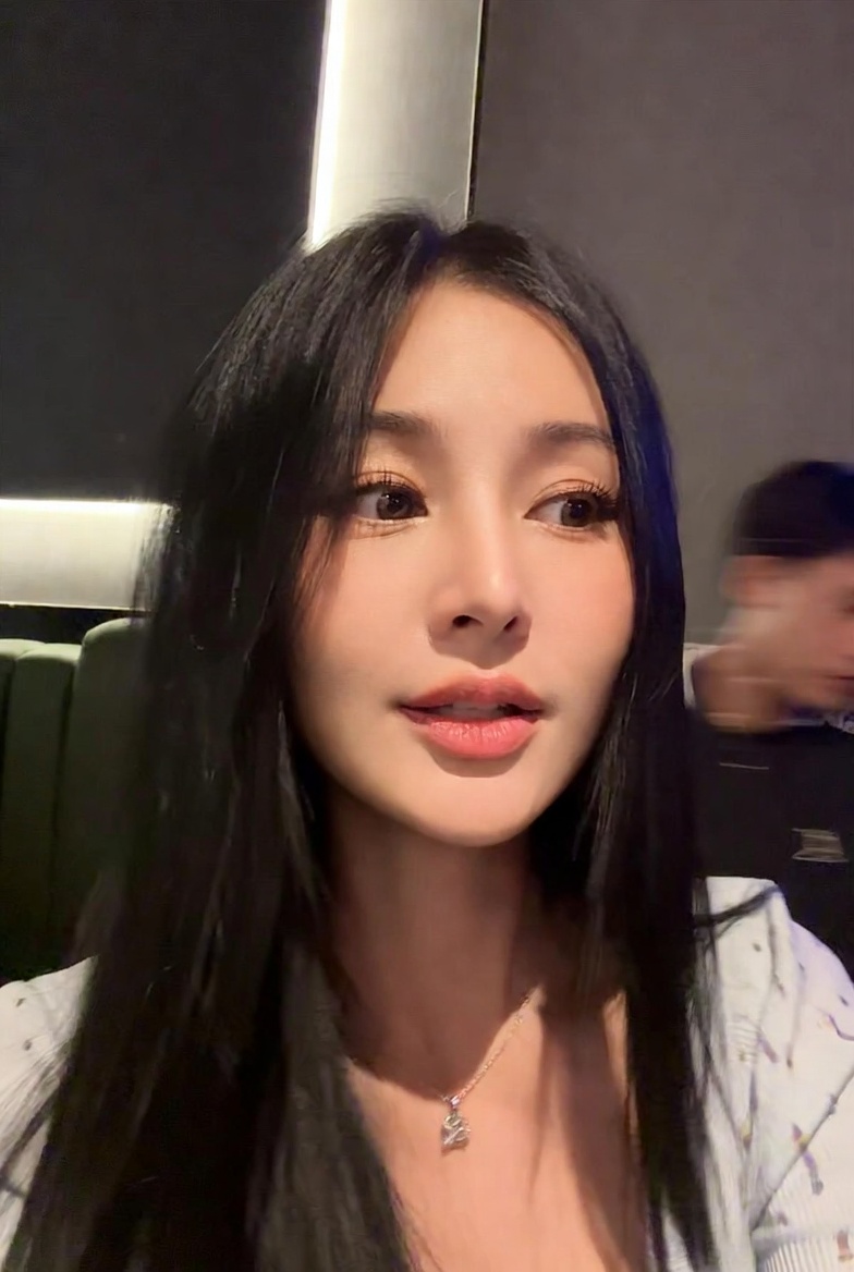 A low-quality iPhone photo of a Vietnamese idol singer in a karaoke setting.